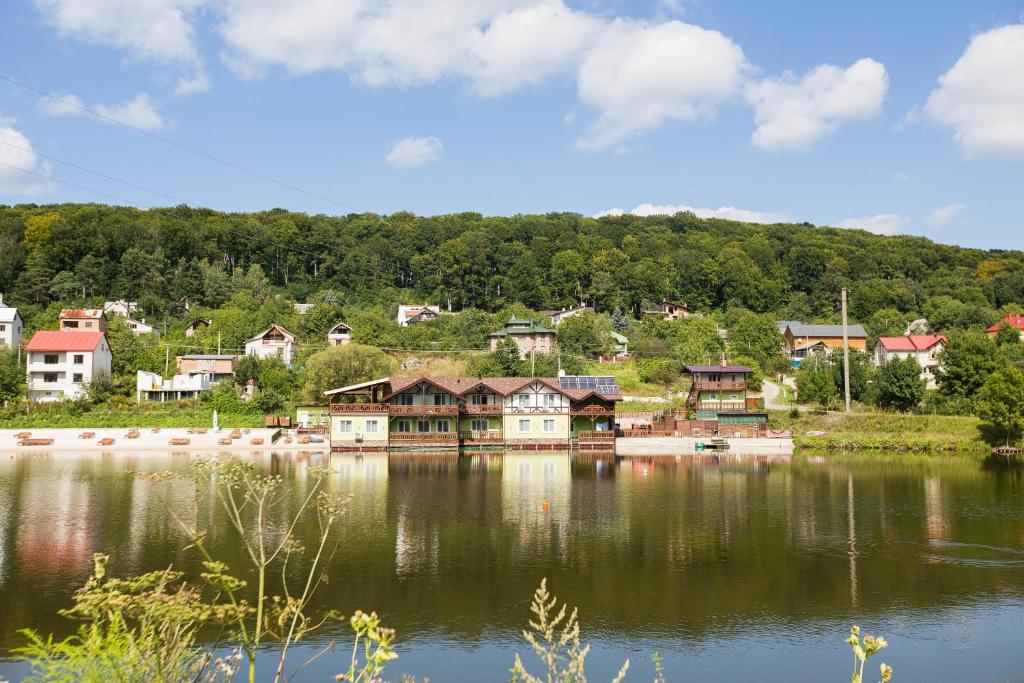 ein kleines Dorf am Ufer eines Sees in der Unterkunft Tartak Resort in Pasiky-Zubryts'ki