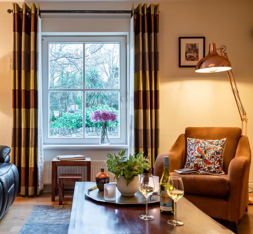 a living room with a chair and a table and a window at Kenmare Townhouse in Kenmare