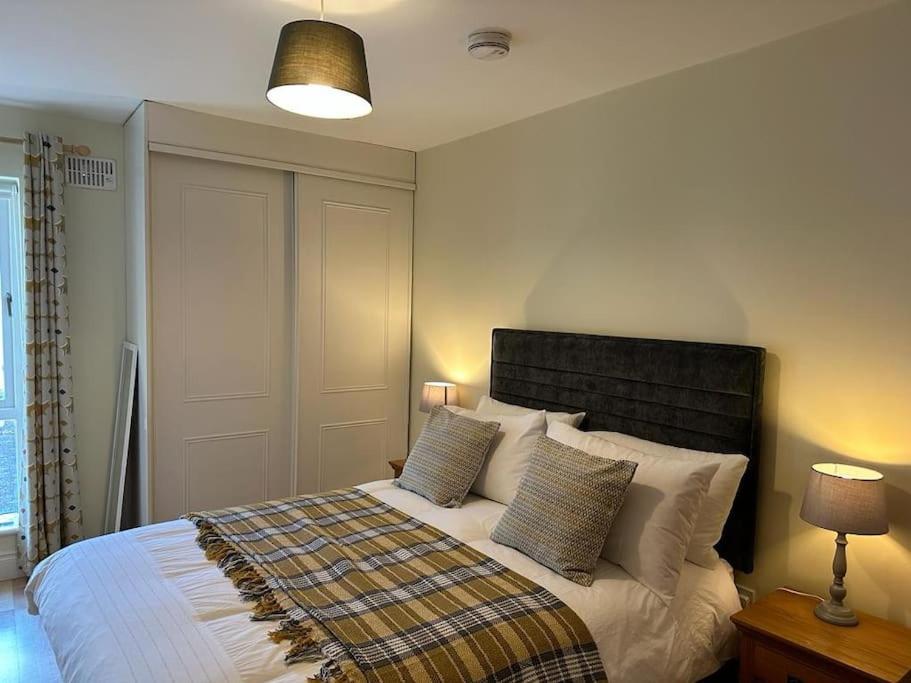 a bedroom with a large bed with two pillows at Town Centre Apartment in Westport