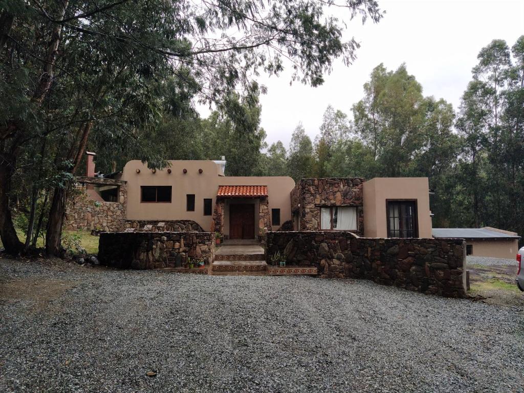 una casa con una pared de piedra y un camino de entrada en EL BOSQUE DE LAS ANIMAS en Tandil
