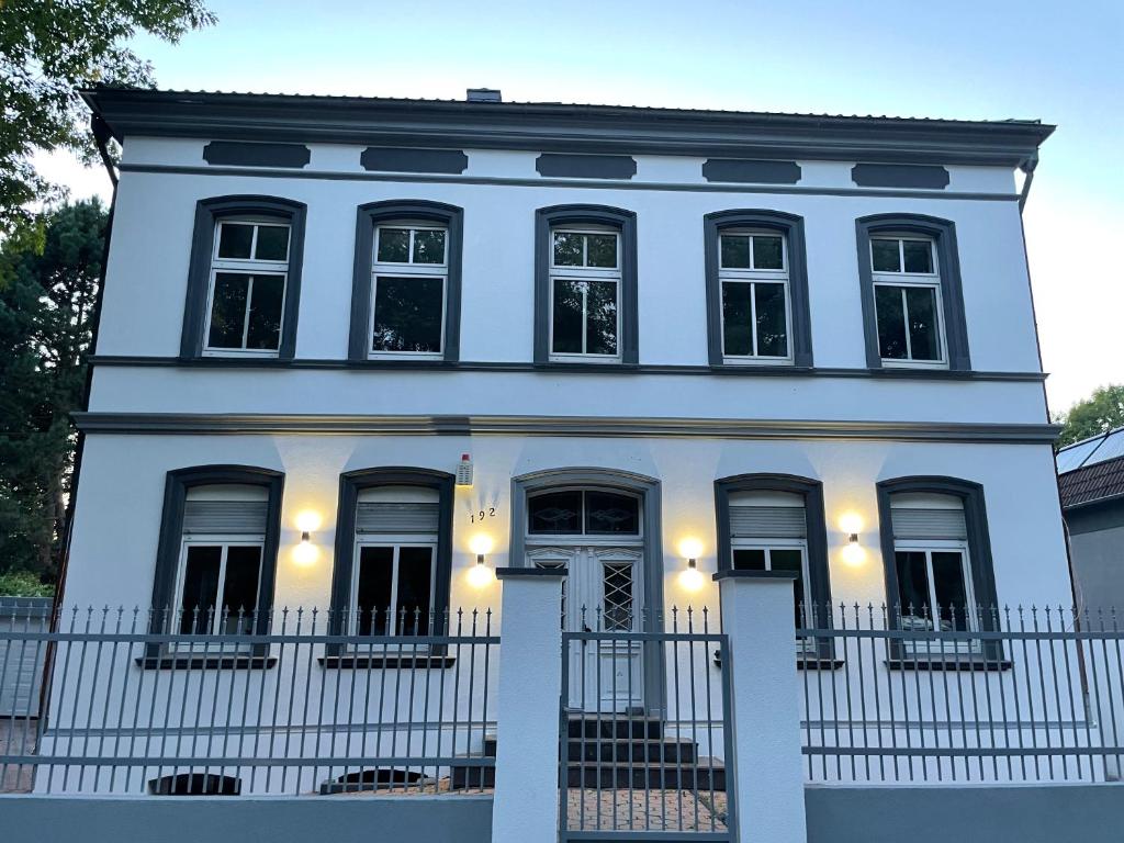 una casa blanca con una valla delante en Buer Appartment en Gelsenkirchen