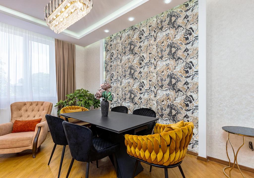 Un comedor con una mesa y sillas negras. en Penthouse in Vake, en Tiflis