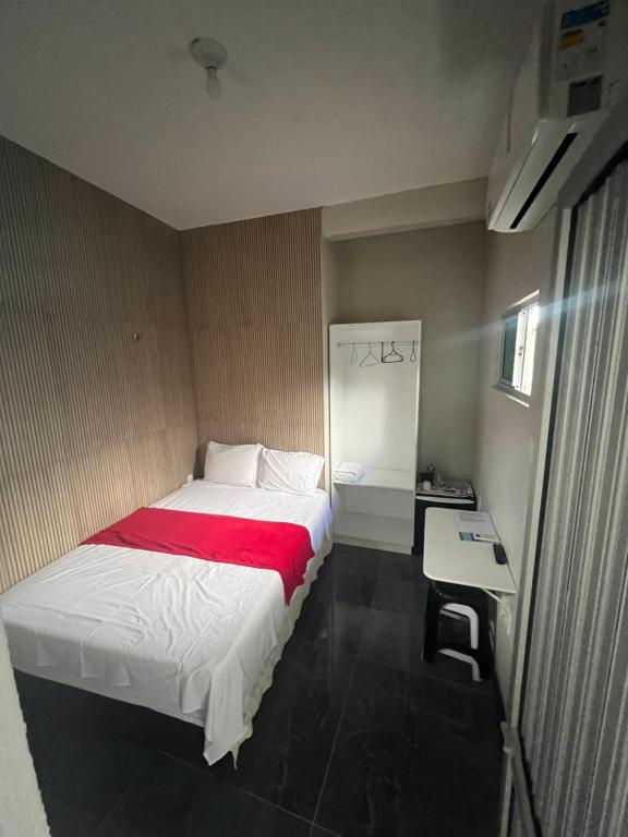 a bedroom with a bed with a red blanket at Pousada da Celma in Fortaleza