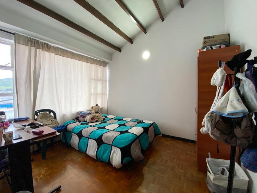 - une chambre avec un lit, un bureau et une fenêtre dans l'établissement La Casa de Lu Los Rosales, à Manizales