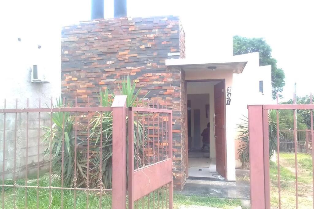 a house with a brick wall and a gate at N8 Casa 2 Dorm Zona Residencial Barrio Villa Lola Artigas in Artigas