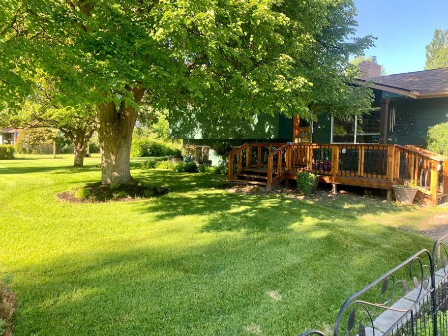une maison avec une terrasse en bois et un arbre dans l'établissement Beautiful hideaway at the end of a cul-de-sac in Missoula, à Missoula