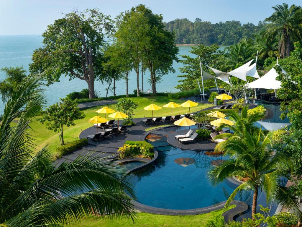 an aerial view of a resort pool with umbrellas at The ShellSea Krabi I Luxury Beach Front Resort & Pool Villa in Ao Nam Mao