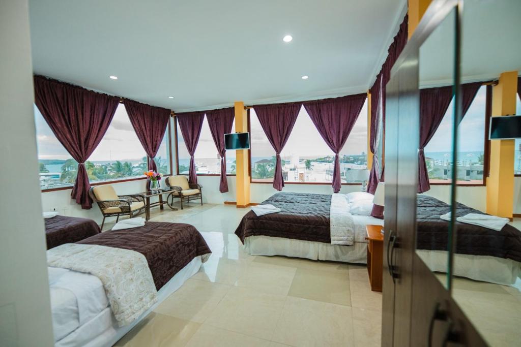 una camera d'albergo con due letti e vista sull'oceano di Galápagos Trip a Puerto Ayora