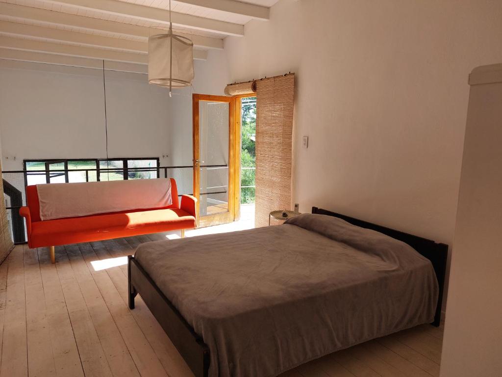 1 dormitorio con cama, sofá y ventana en Casa Arbet - Villa 25 de Mayo, San Rafael, Mendoza en San Rafael