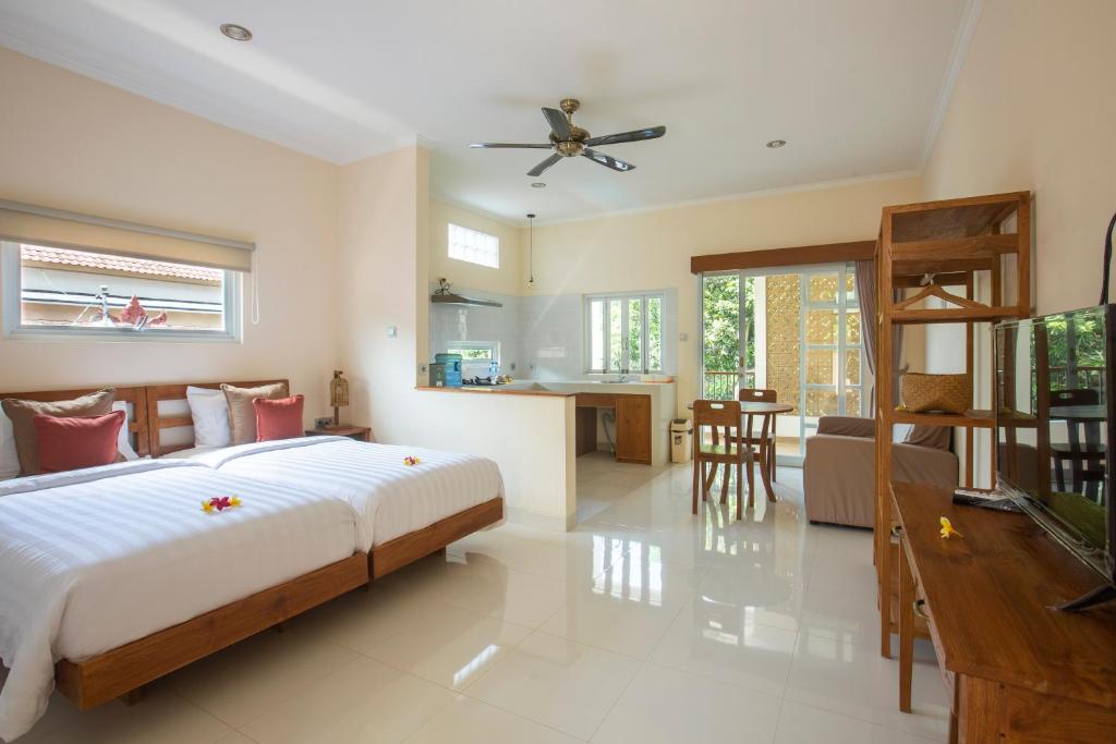 a bedroom with a bed and a living room and a kitchen at Donguri House Bali in Jimbaran