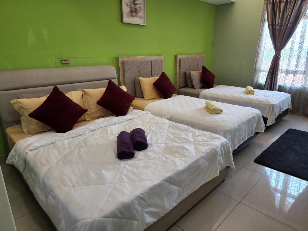 - 2 lits dans une chambre avec des chaussures violettes dans l'établissement The Viana Apartment V, à Kota Bharu