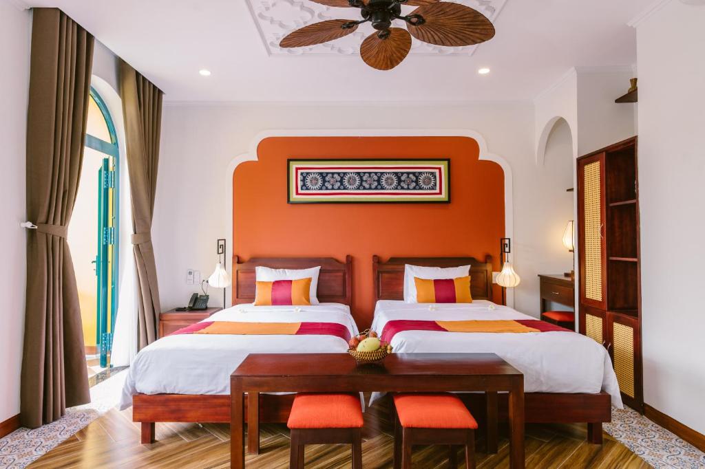 Postel nebo postele na pokoji v ubytování De'Colore Villa Hoi An