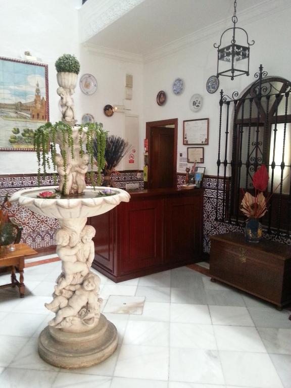 a living room with a fountain in the middle of a room at Hostal Trajano in Seville