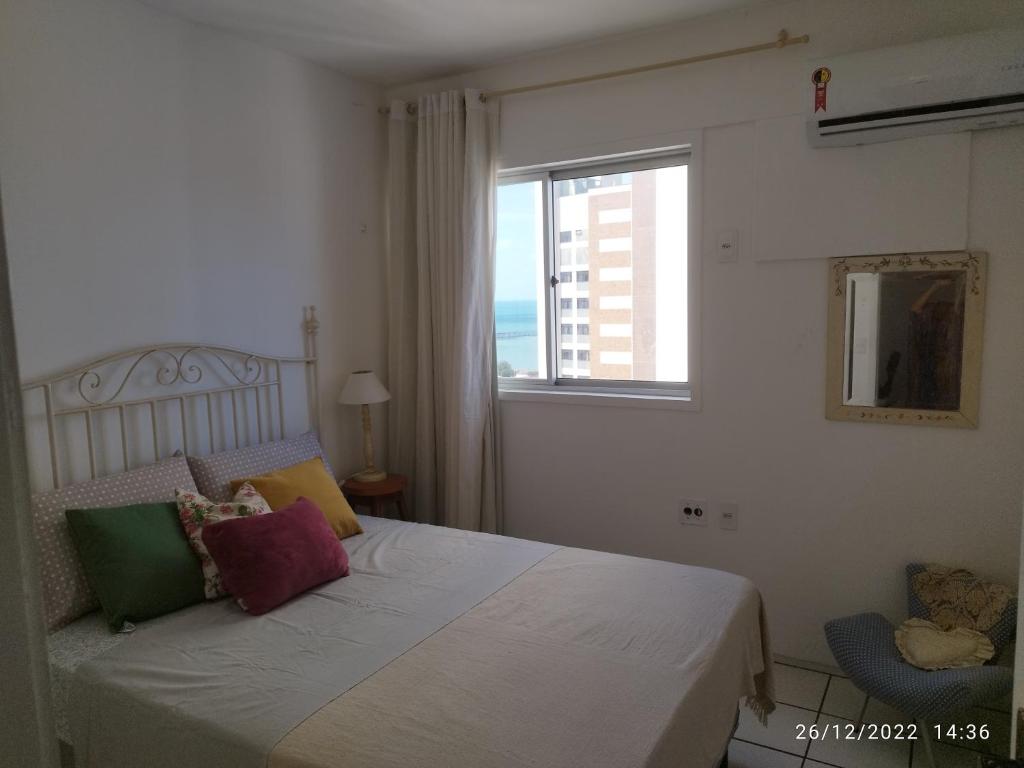 a bedroom with a white bed with a window at apartamento na praia de Iracema com vista mar in Fortaleza