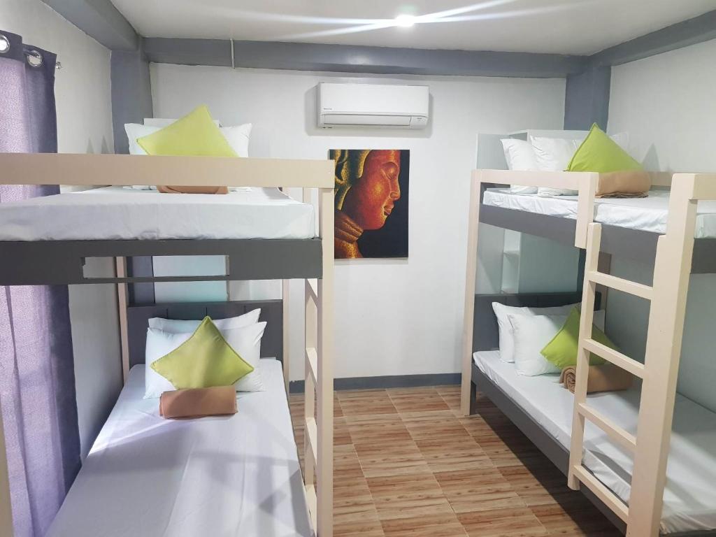 a room with three bunk beds in it at WOZA INN BORACAY in Boracay