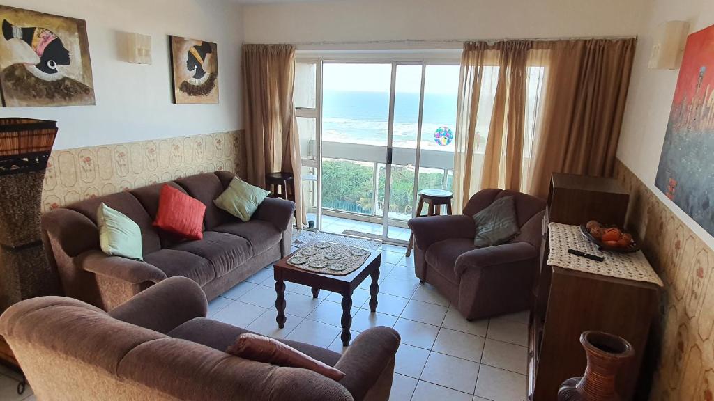 a living room with couches and a view of the ocean at Stella Maris 53 in Amanzimtoti