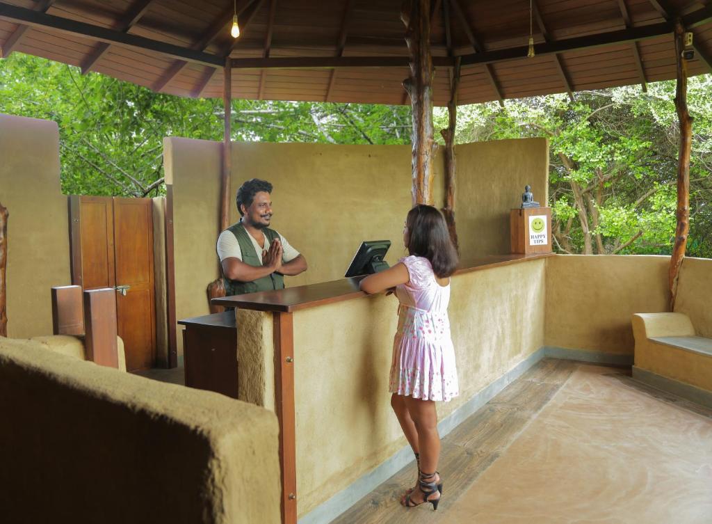 a little girl standing at a counter with a man at Leopard Nest - Glamping in Yala in Yala