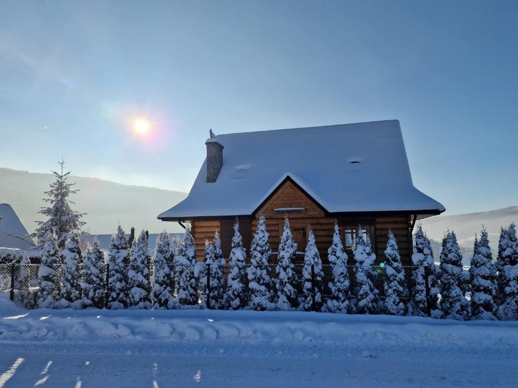 une cabine dans la neige avec le soleil en arrière-plan dans l'établissement Zawoja hrabkowa Jastrzębowka, à Zawoja