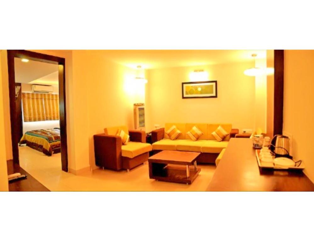 印多爾的住宿－Hotel Pearl,Indore，客厅配有沙发和桌子