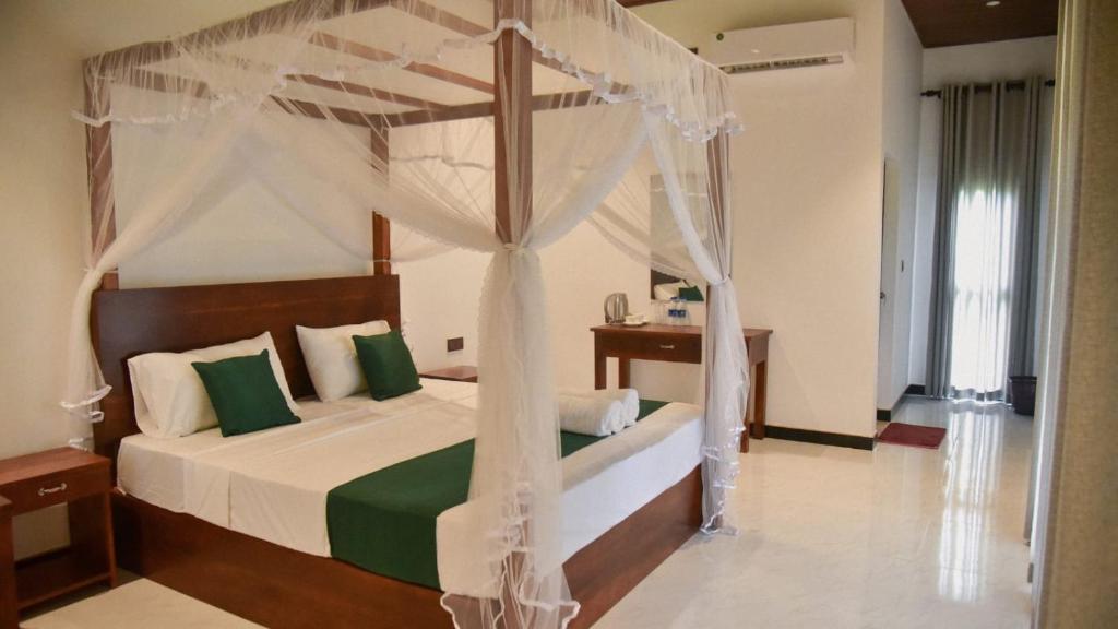 - une chambre avec un lit à baldaquin dans l'établissement Sigiriya Paradise Inn, à Sigirîya