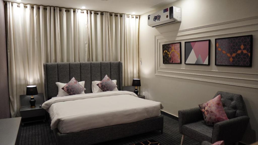 una camera d'albergo con letto e sedia di La Maison Islamabad a Islamabad