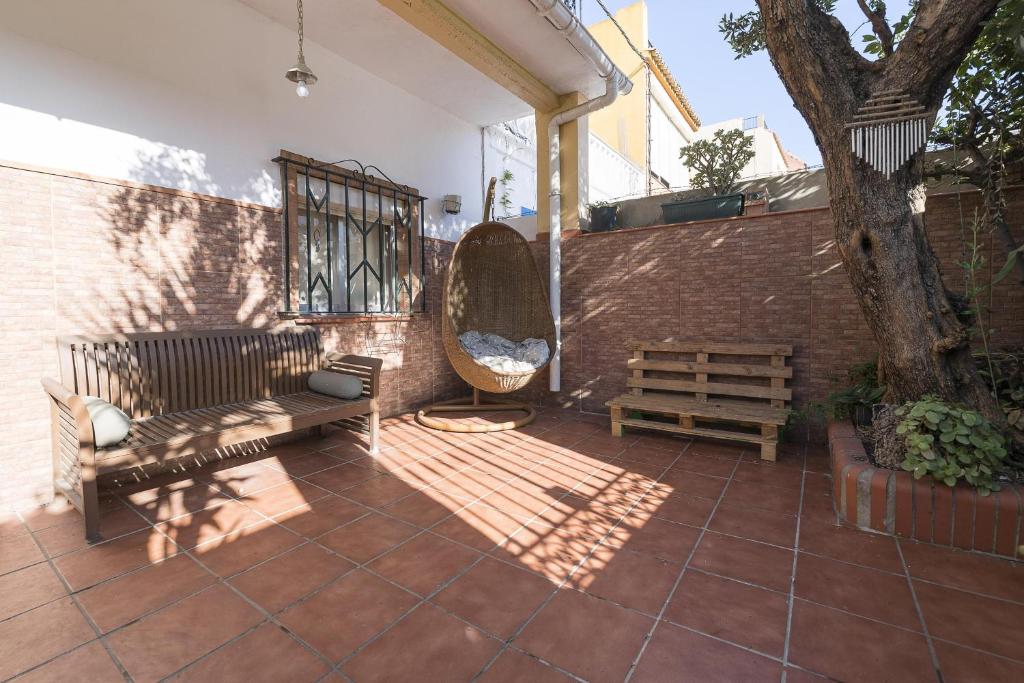 a patio with two benches and a tree at Casa Del Olivo in Algeciras