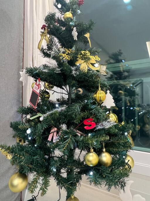 choinkę świąteczną ze złotymi ozdobami w obiekcie Cozy Space with Modern Interior in Hwaseong w mieście Hwaseong
