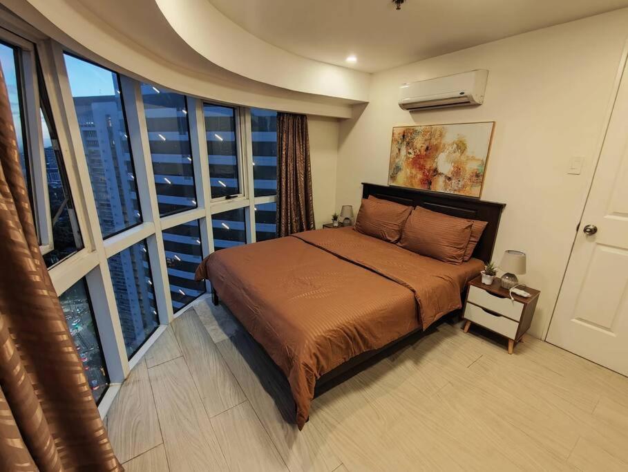 1 dormitorio con cama y ventana grande en A2J Luxury 2BR Suite Near High Street BGC Taguig, en Manila