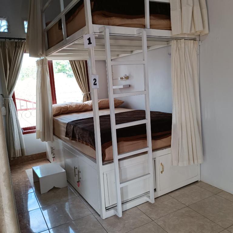 a bedroom with two bunk beds in a room at BSH (Bu Sud's House) Yogyakarta in Yogyakarta