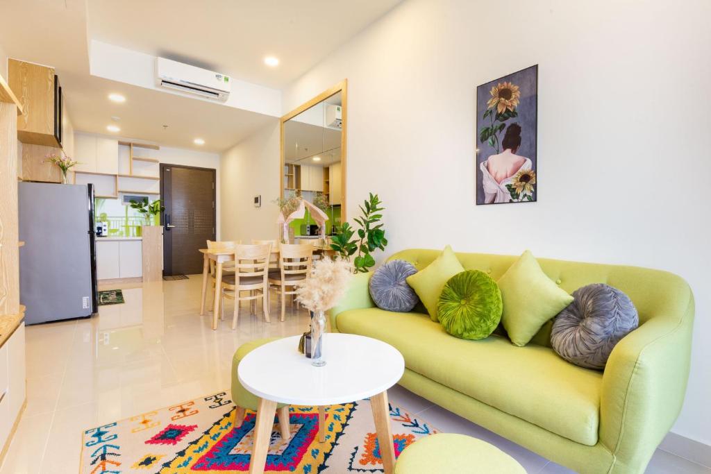 胡志明市Yu Stay Green Premium Luxury 2bedrooms Condotel in D1 near Bui Vien Street的客厅里有一张绿色的沙发和一张桌子