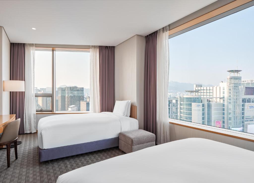 a hotel room with two beds and a large window at Sotetsu Hotels The Splaisir Seoul Dongdaemun in Seoul
