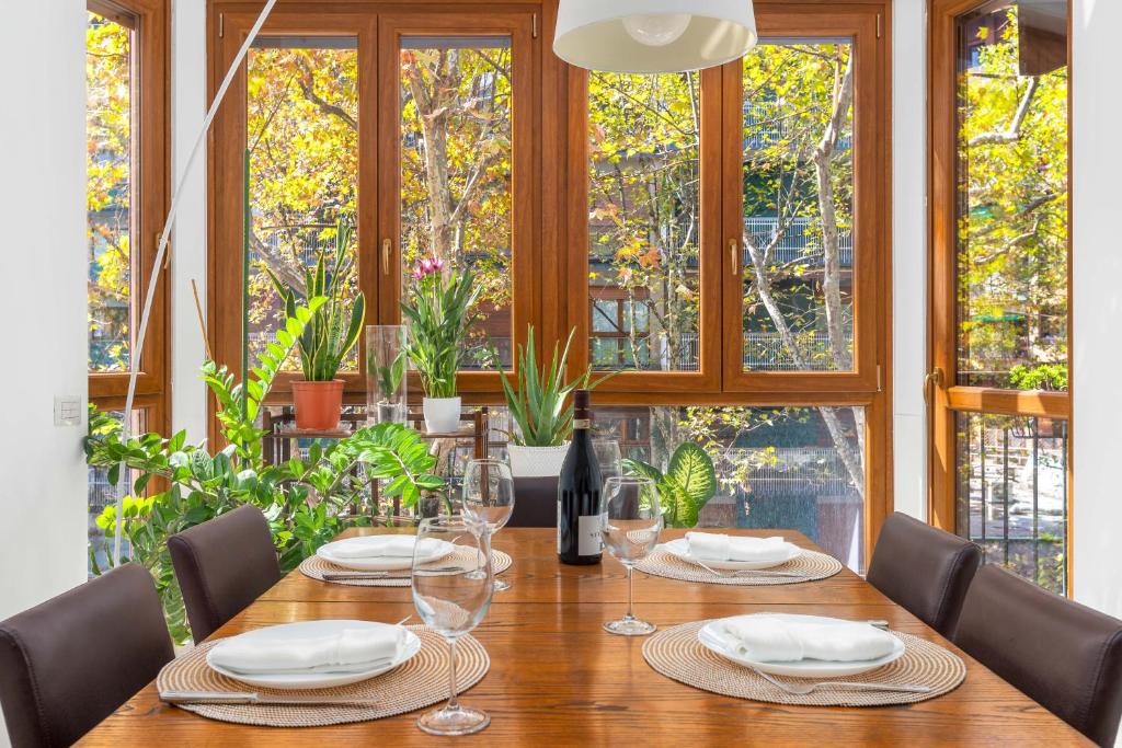 mesa de comedor con sillas, gafas y ventanas en [Marghera-Fiera] Appartamento elegante e luminoso en Milán