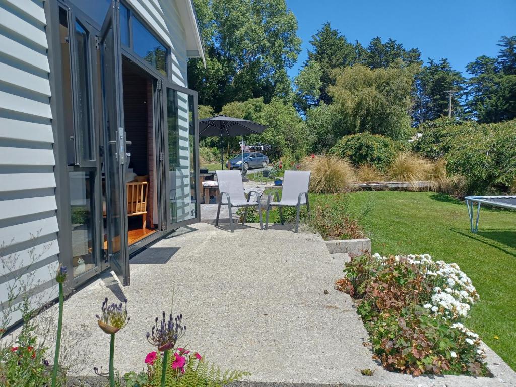 a patio with white chairs and an umbrella at Hunter Farm in Kononi