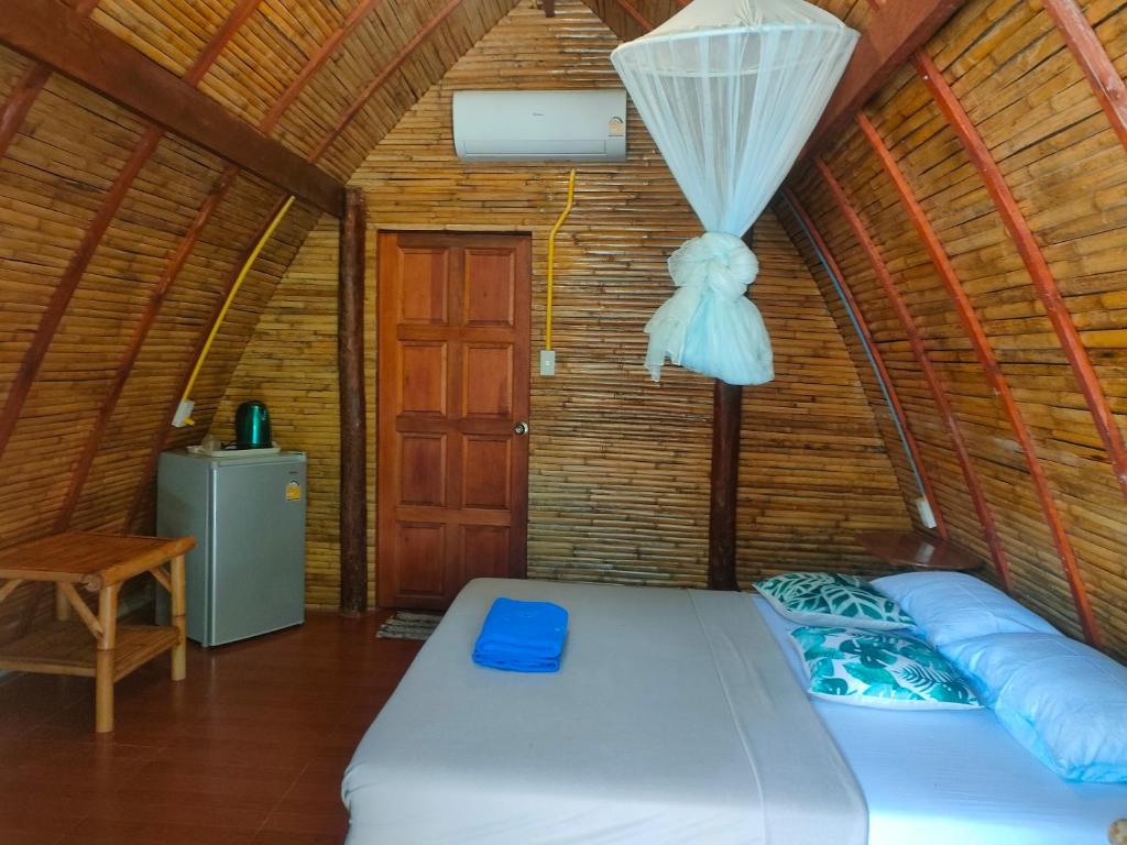 a bed in a room with a ceiling at Baanmaiphai Resort in Ban Mo Nae