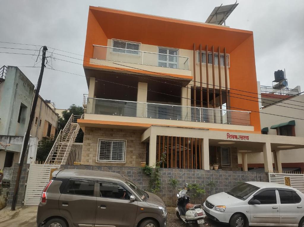 two cars parked in front of a building at Shiv- Vatsalya Homestay in Nashik