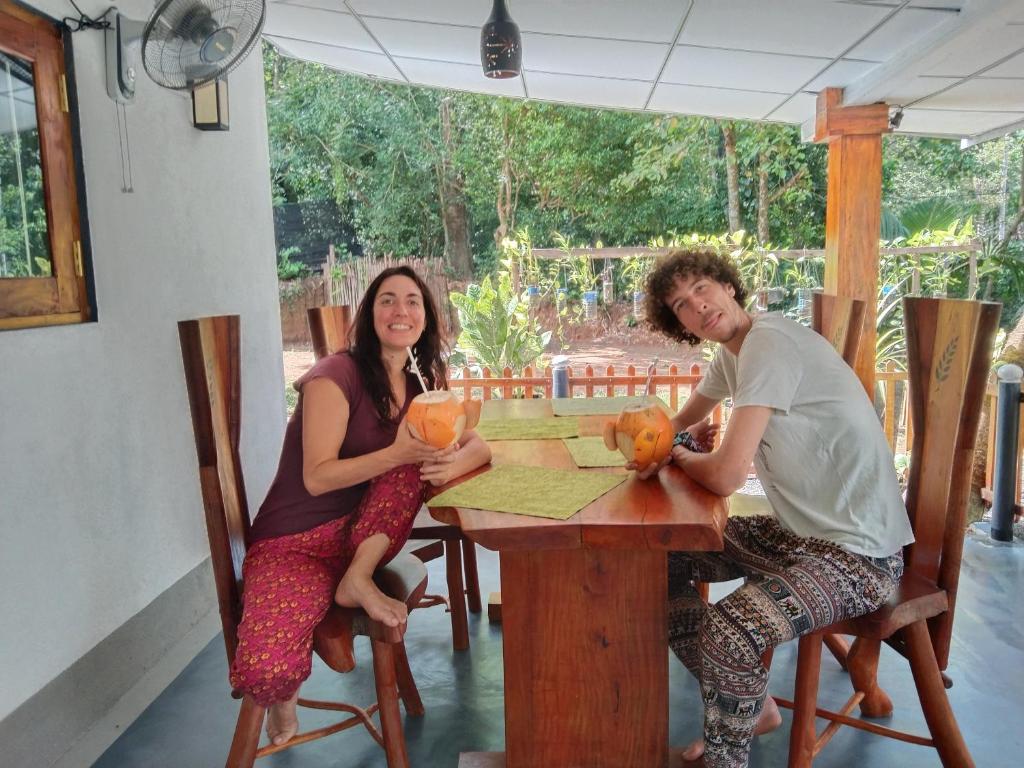a man and a woman sitting at a table at Lovers Green Villa in Matara