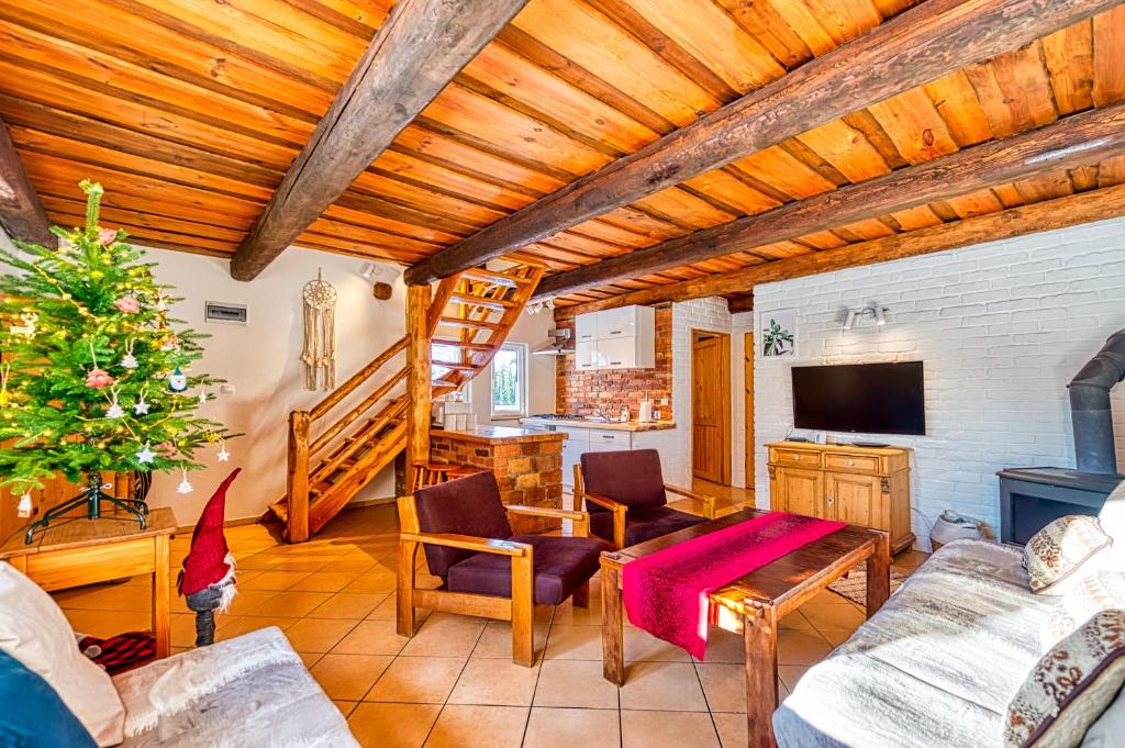 a living room with wooden ceilings and a christmas tree at Domki nad strumykiem in Mirsk