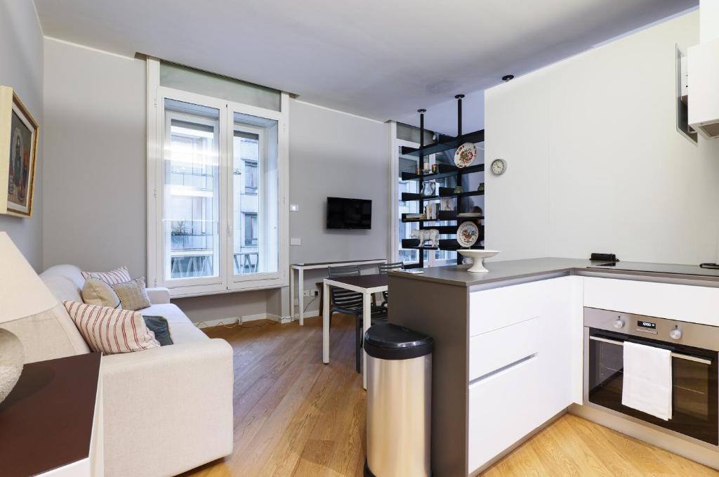 uma cozinha e sala de estar com um sofá e uma mesa em Contempora Apartments - Visconti di Modrone em Milão