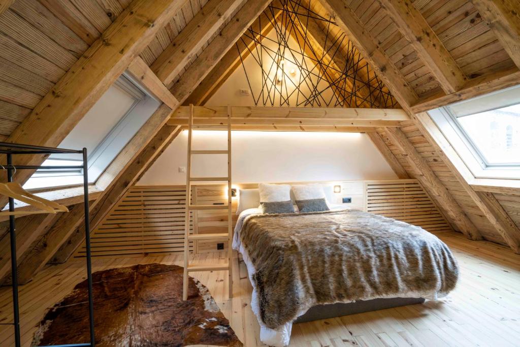 a bedroom with a bed in a wooden attic at Muntanyó Luxury Lodge con sauna, parking y guardaesquis en Ruda in Tredós