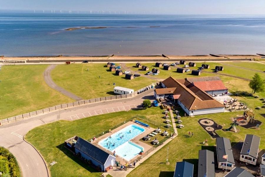 an aerial view of a resort with a pool and the ocean at Oyster Etchingham SEAVIEW in Whitstable