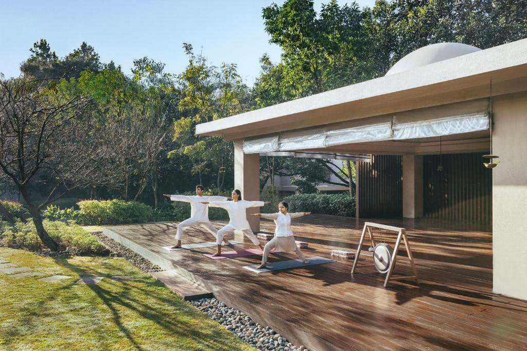 a group of people doing yoga on a deck at Six Senses Vana - A Wellness Retreat in Dehradun