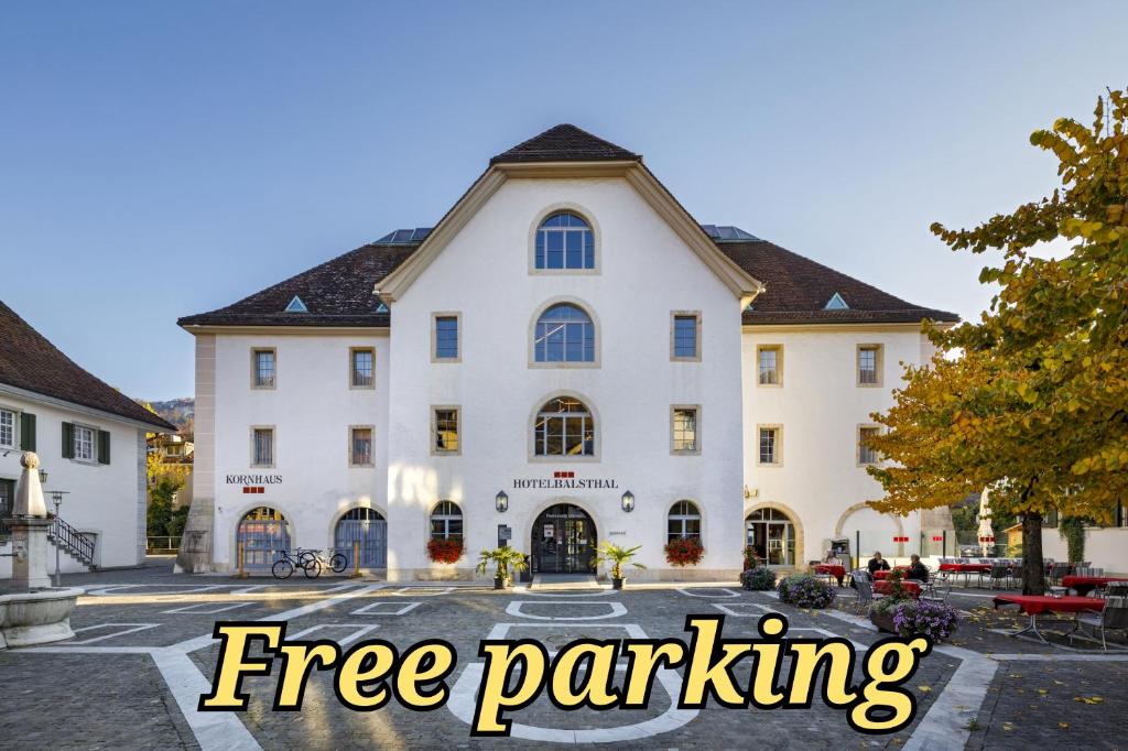 a large white building with the words free parking at Hotel Balsthal in Balsthal