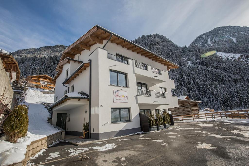 a large white building with mountains in the background at Aurora Appartements in Neustift im Stubaital