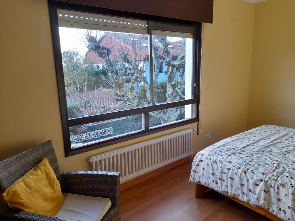 sypialnia z łóżkiem i dużym oknem w obiekcie Casa con vistas a 100 metros de una playa en Panxón w mieście Nigrán