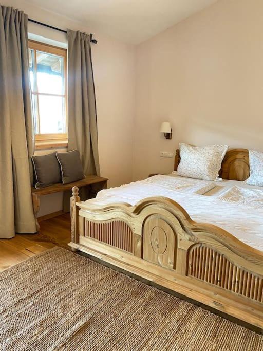 Schlafzimmer mit einem großen Holzbett und einem Fenster in der Unterkunft Wohnung in Kirchberg in Tirol in Kirchberg in Tirol
