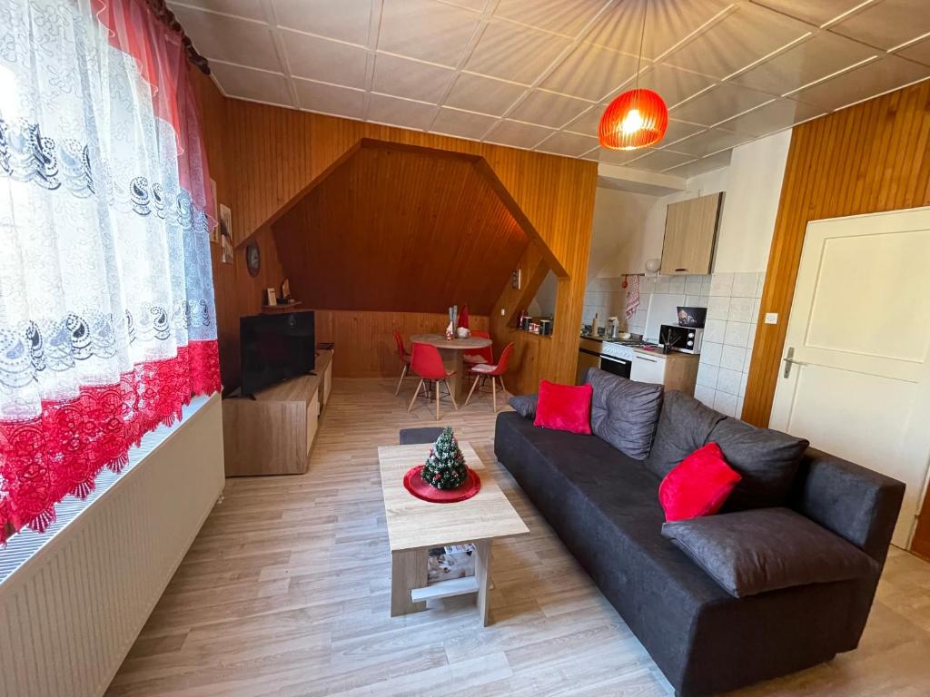 een woonkamer met een bank en een tafel bij Studio Apartman Poljančić in Ravna Gora