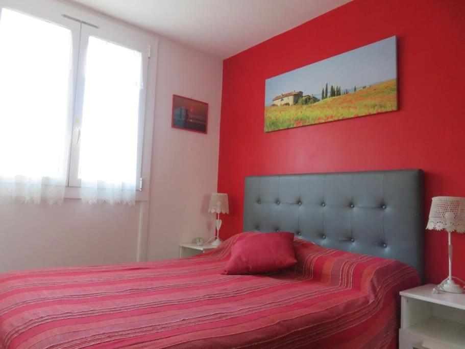 - une chambre rouge avec un lit et une couverture rouge dans l'établissement NICE NORD 2 PIECES CALMES,WIFI,CLIM,BALCON,PARKING, à Nice