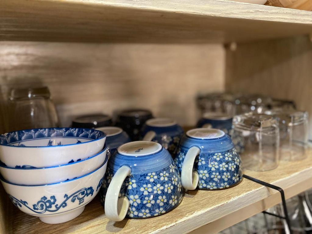 a shelf with blue and white bowls and glasses at The Palmian City Center Serviced Apartment in Ho Chi Minh City
