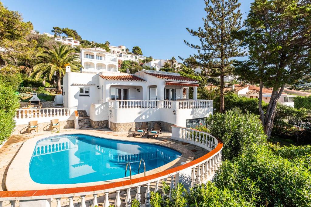 a large white house with a swimming pool in front of it at Villa Nineta in Son Bou