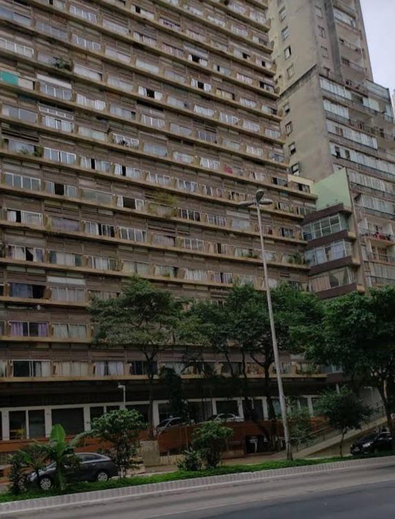 un gran edificio de apartamentos con árboles delante de él en Loft Bela Vista, en São Paulo